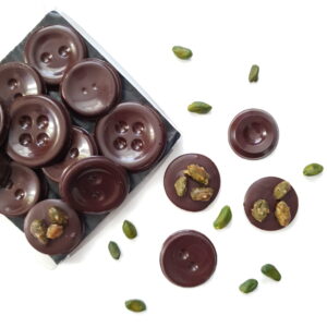 an open box of dark chocolate and caramelised pistachio buttons